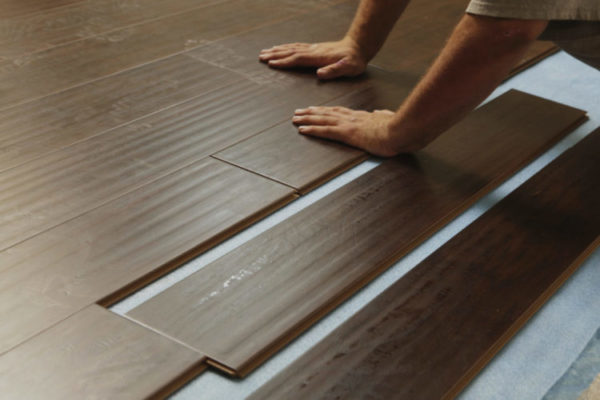 Man Installing New Laminate Wood Flooring Abstract.